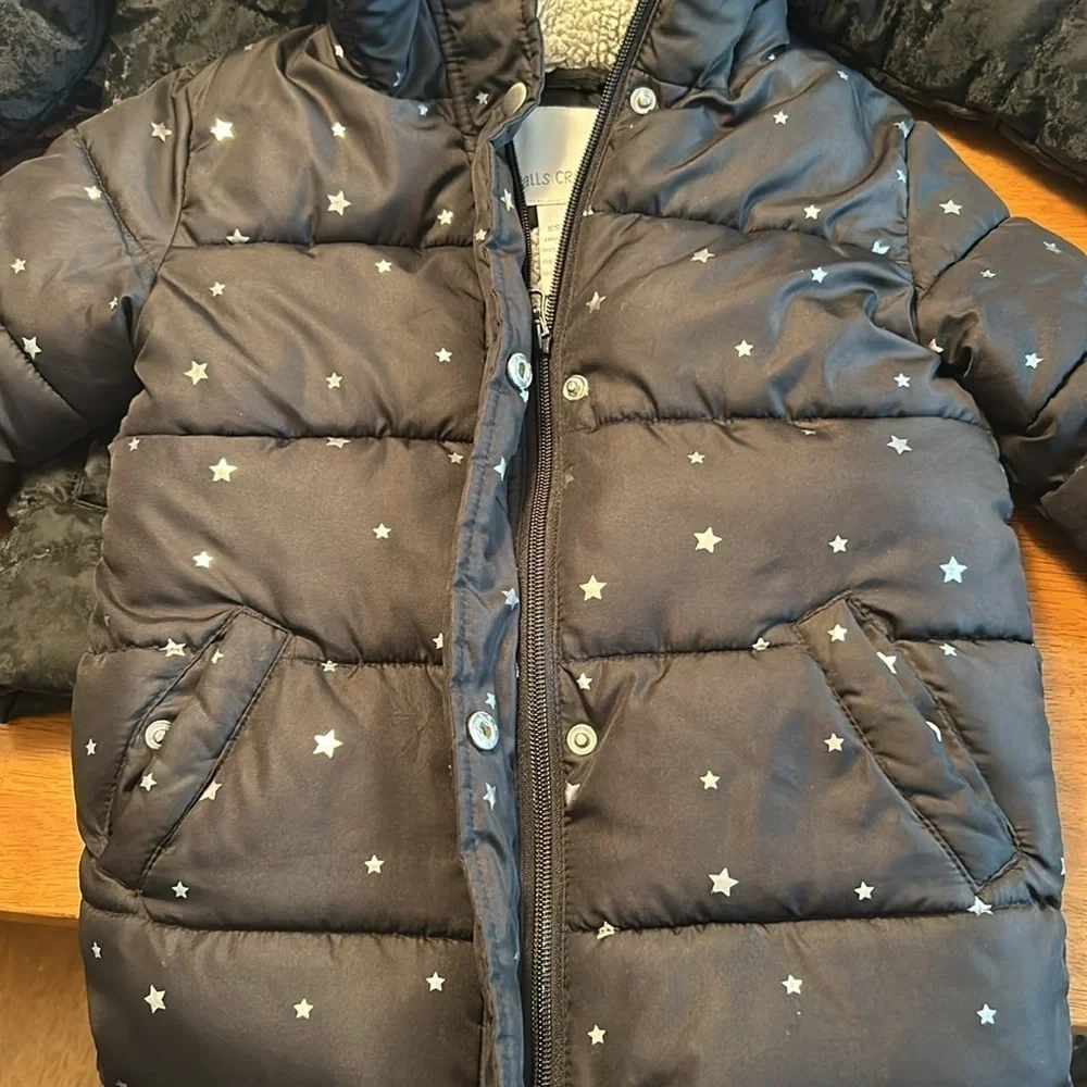 Girls hooded winter coat size XS (4/5) in black with silver stars.